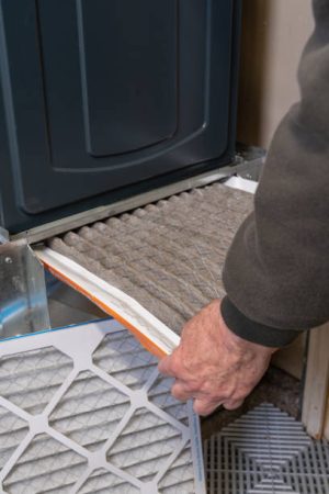 Replacing dirty furnace filter in home by man Replacing dirty furnace filter in home by man