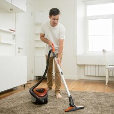 happy-smiling-man-cleaning-carpet
