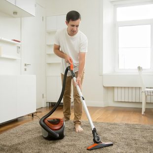 happy-smiling-man-cleaning-carpet